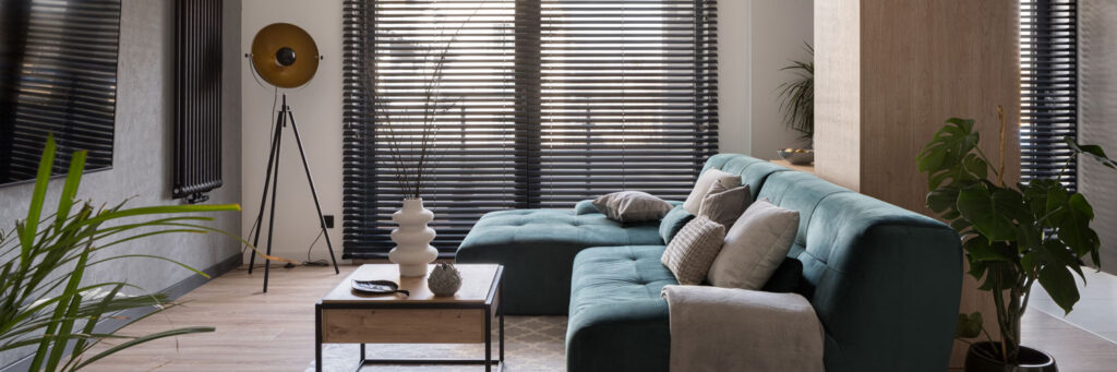 A dark horizontal venetian blinds covering a large window.