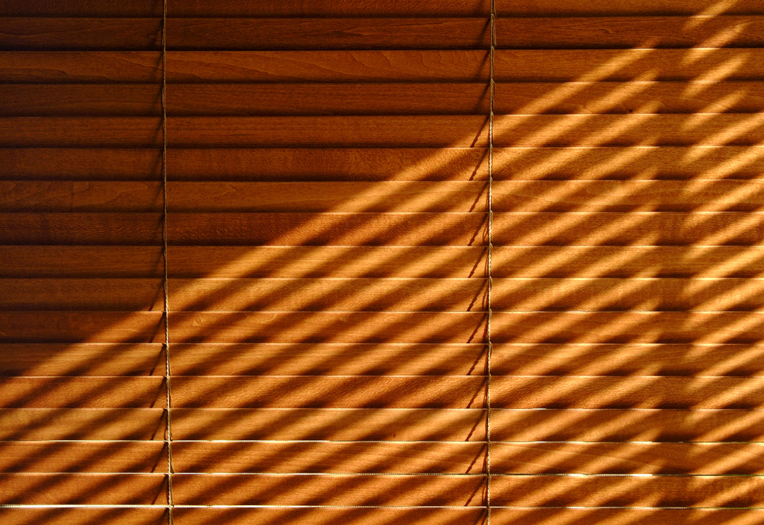 A close-up of a set of brown wooden horizontal blinds.
