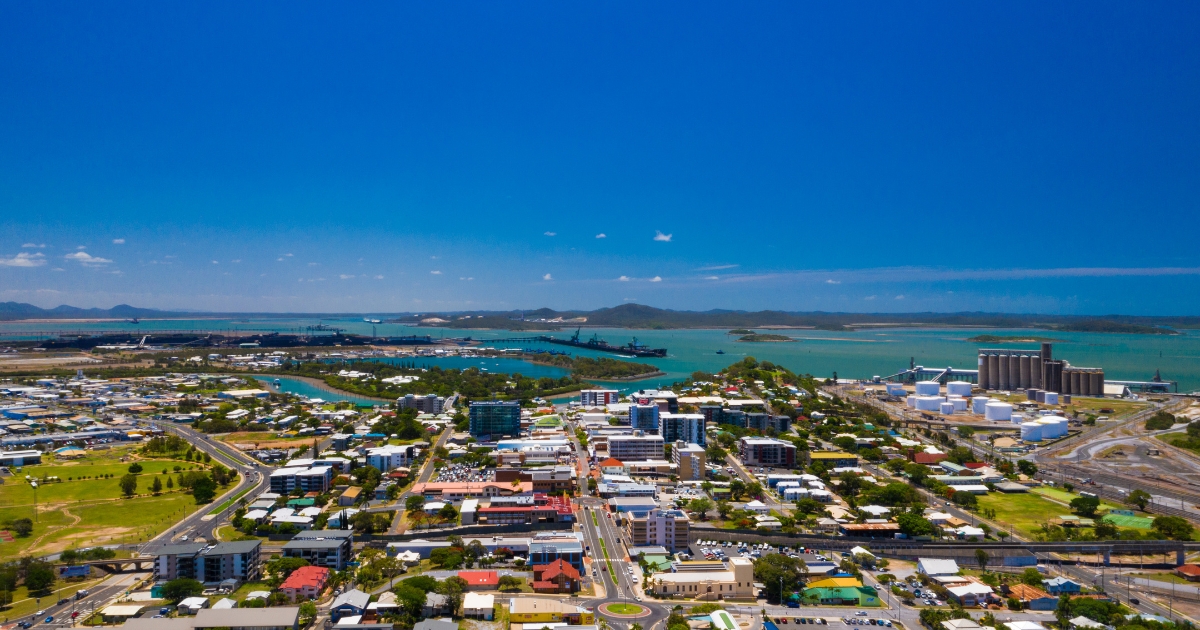 An expansive aerial view of a coastal city and industrial port in Gladstone.
