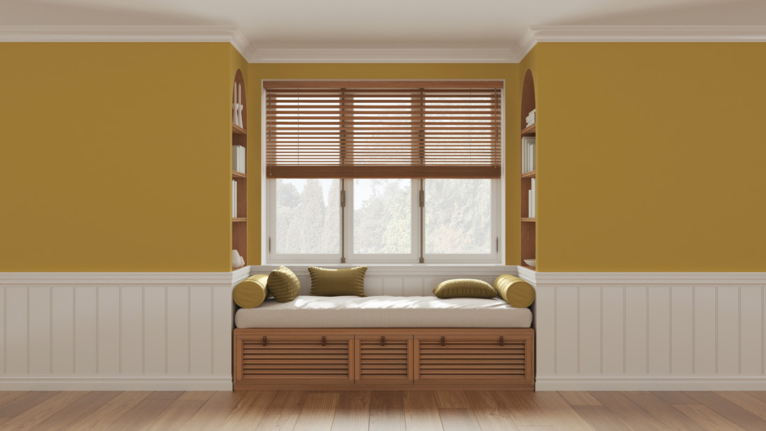 A cosy reading nook featuring a built-in window seat with olive green pillows