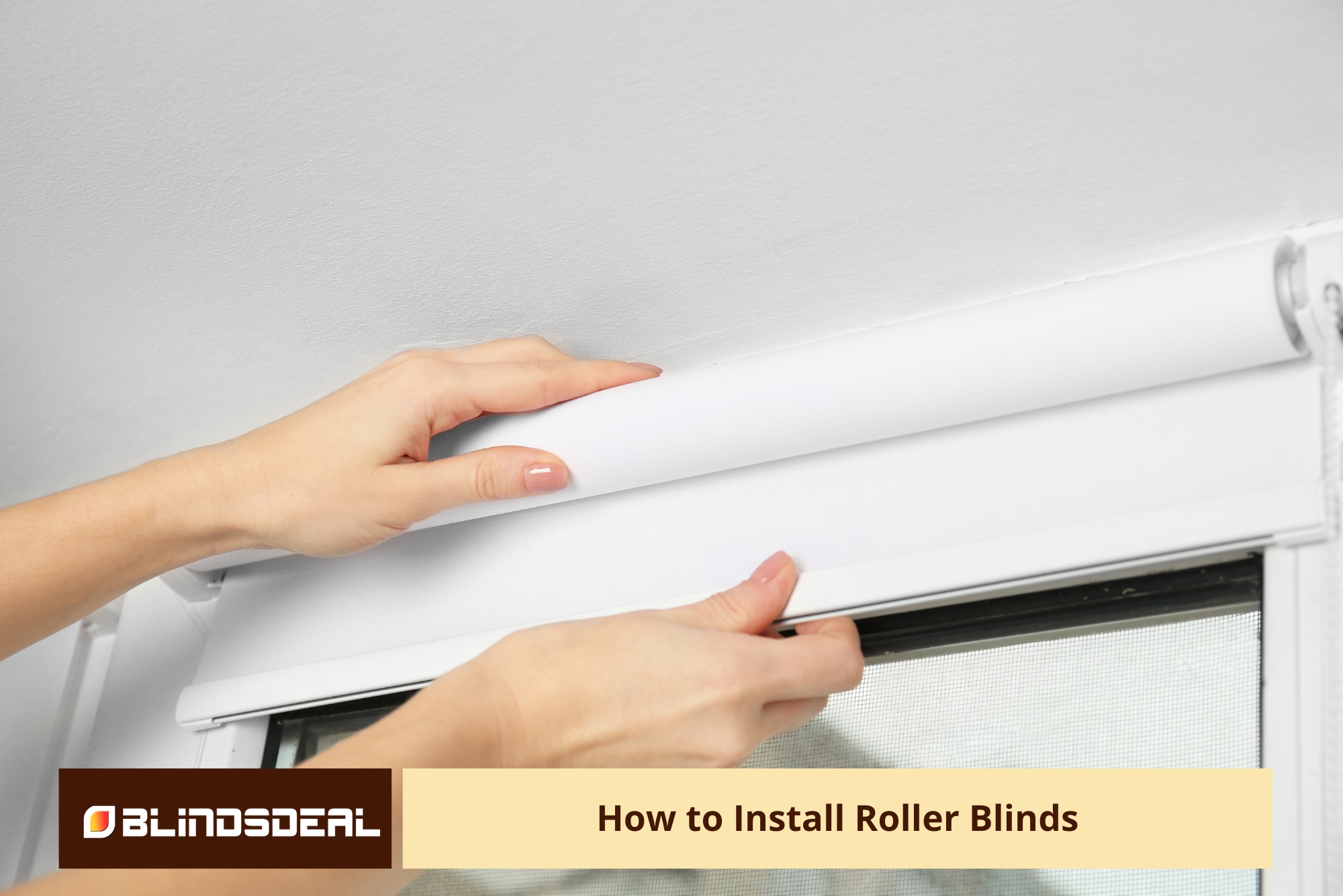 A close-up of hands installing a white roller blind into a window frame