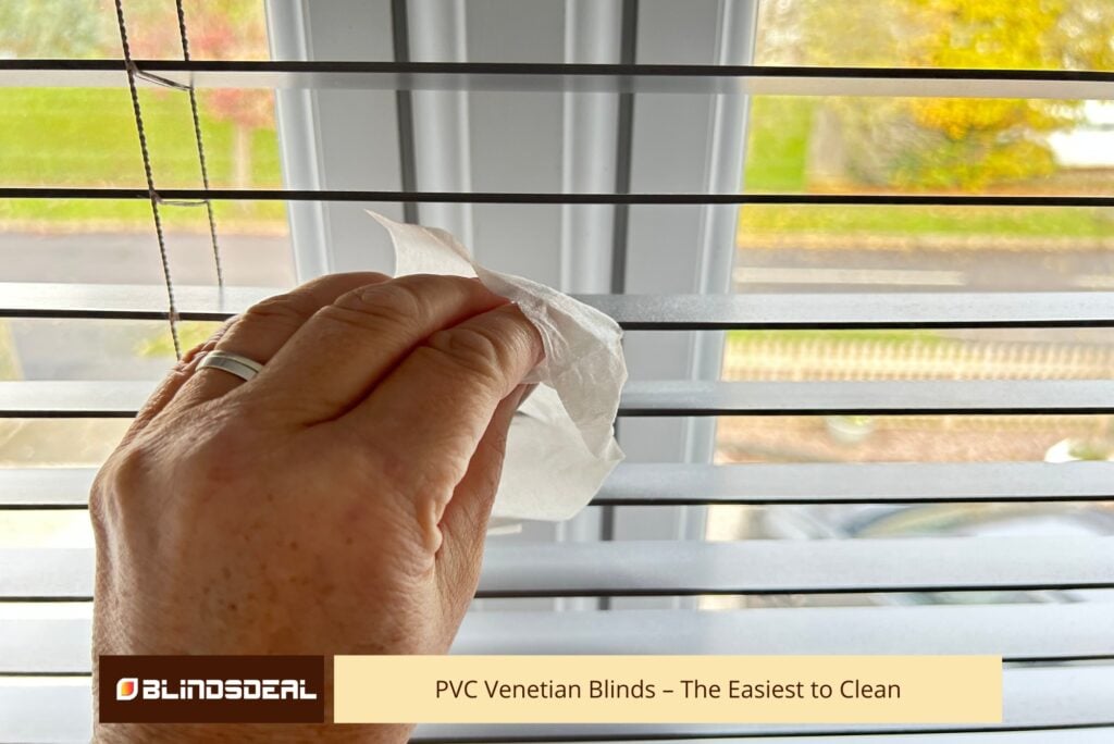 Close-up of PVC venetian blind slats being wiped clean with a damp microfibre cloth