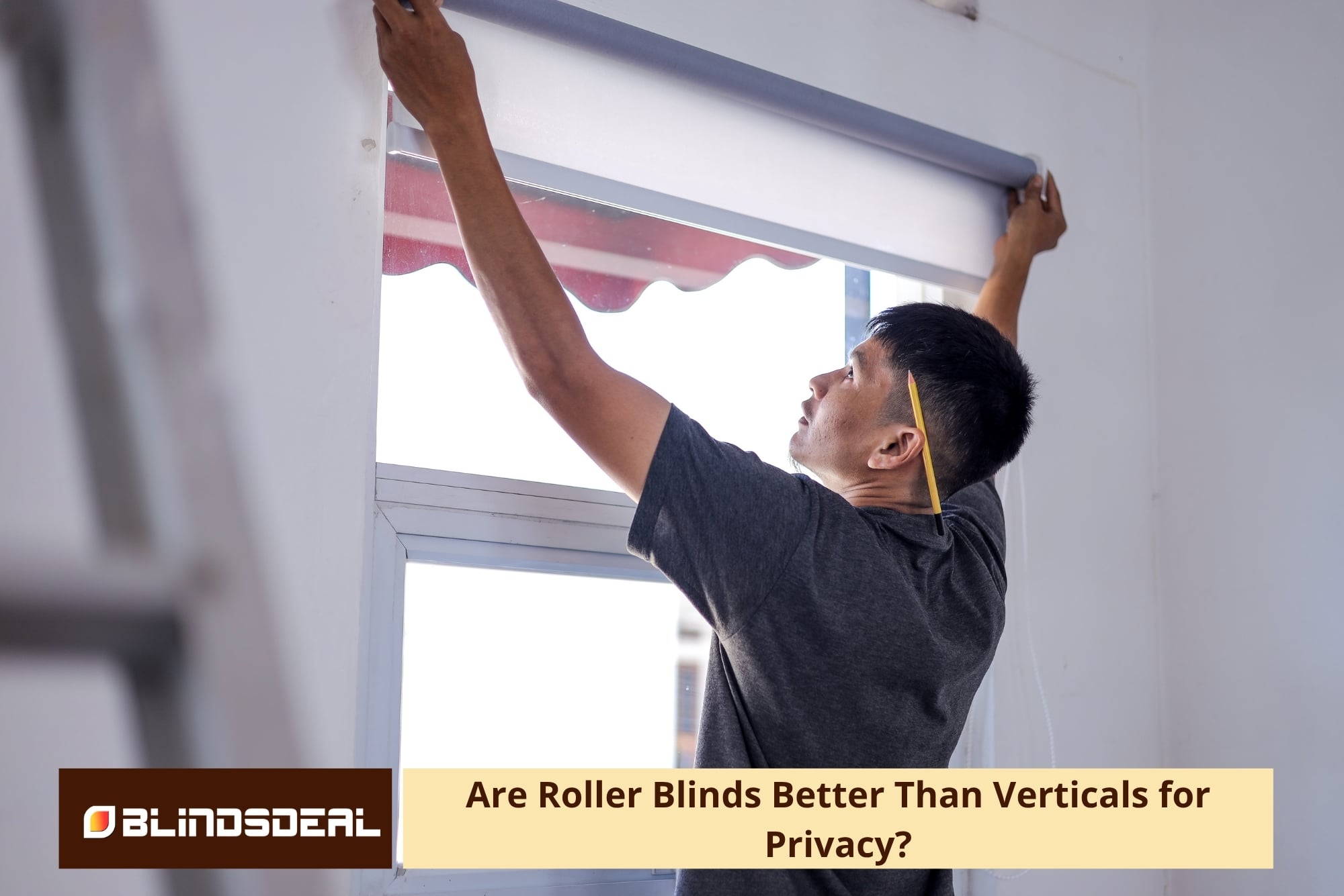 A man installing a grey roller blind over a window