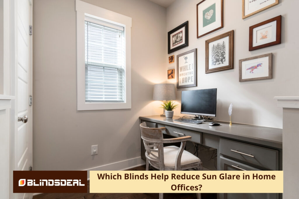 A cosy home office nook with a desk, computer monitor, gallery wall, and a window with white Venetian blinds