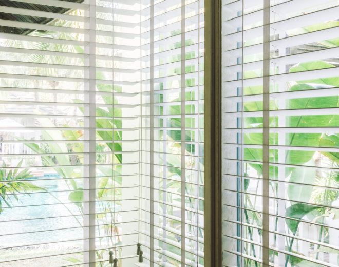 White horizontal venetian blinds in a large corner window